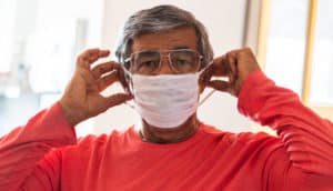 senior adult puts on mask