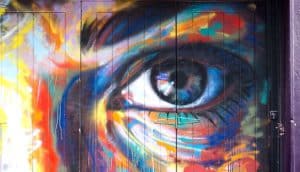 A colorful painting on a wall of an eye