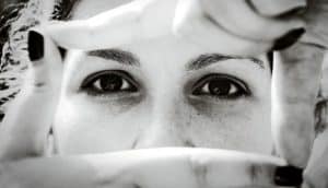 A woman frames her face with her fingers