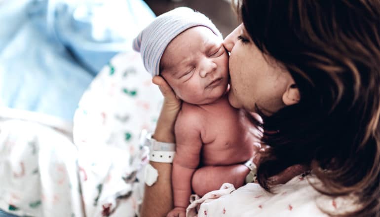 A mother holds her newborn baby