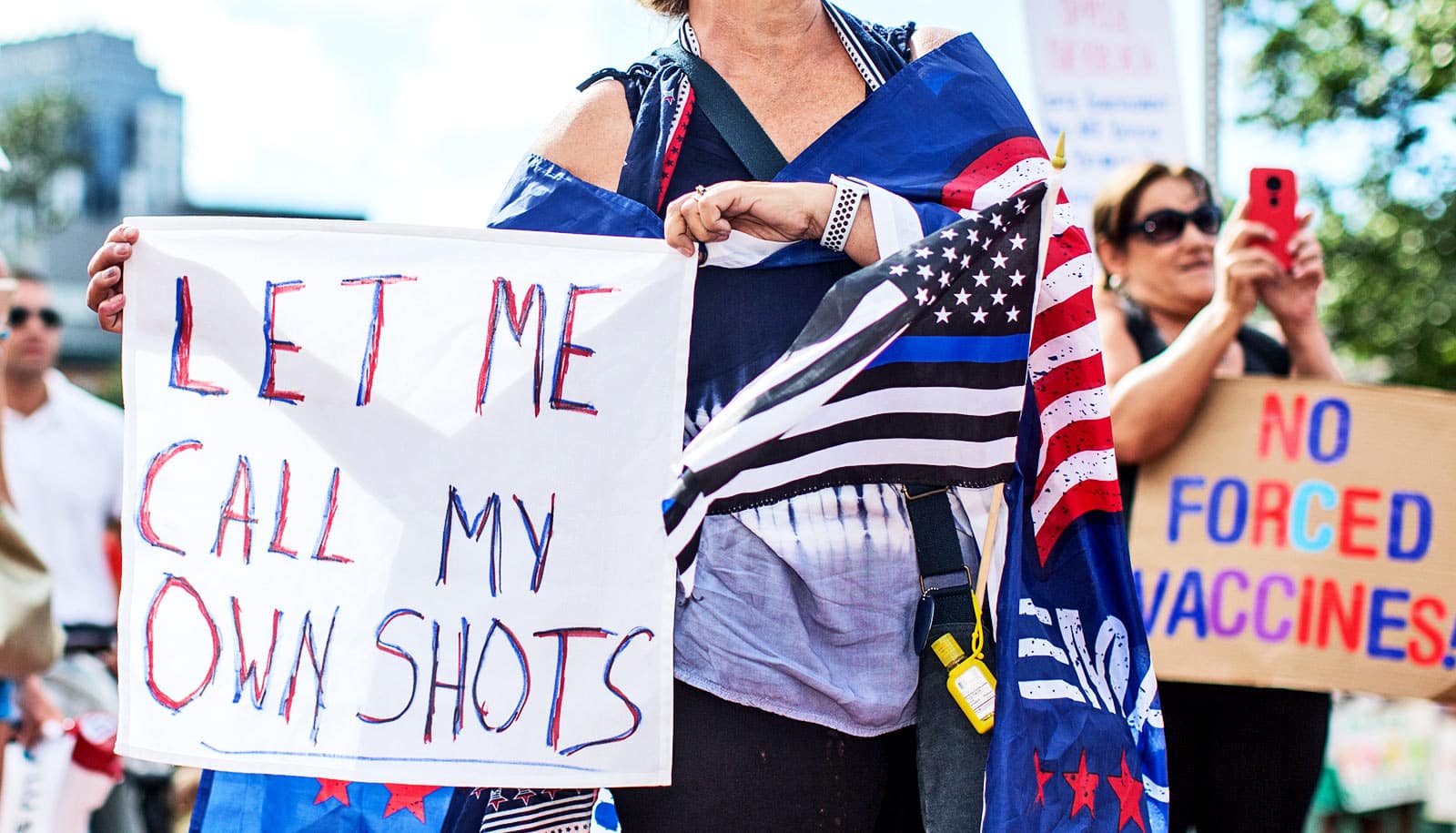 Anti-vaccine activists hold signs in front of the Massachusetts State House during a protest in August, 2020. (Credit:  Scott Eisen/Getty Images) A st