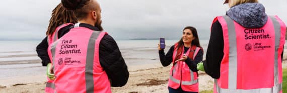 diverse group of people in pink vests that read "I'm a citizen scientist" and "litter intelligence"