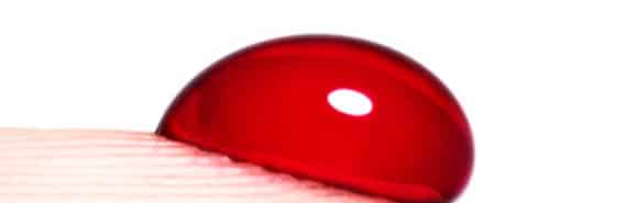 A drop of blood on a person's finger tip