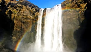 A waterfall with a rainbow in front of it