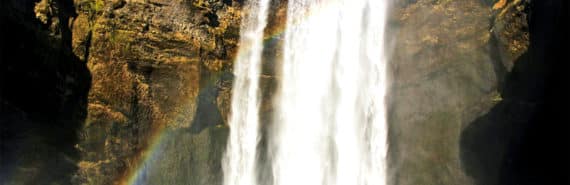 A waterfall with a rainbow in front of it