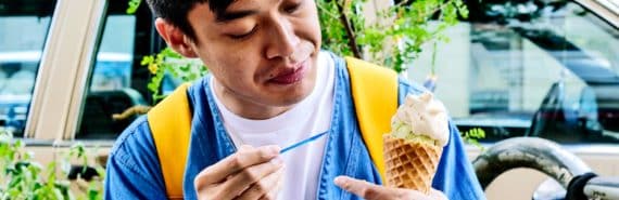 A man looks at this ice cream cone while holding a spoon
