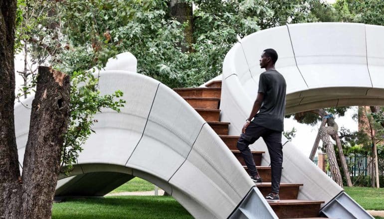 Een man loopt de trap op van de 3D-geprinte betonnen brug