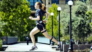 A woman runs wearing the calorie tracker on her waist and leg