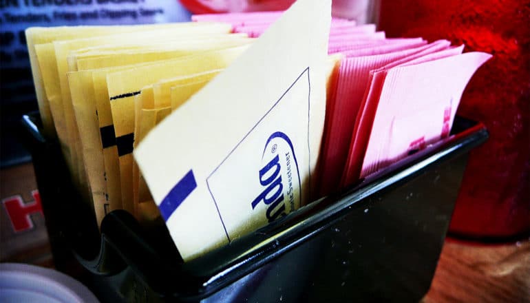 Artificial sweeteners in a small container on a table