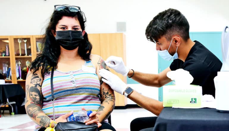 Een jonge vrouw krijgt haar tweede vaccin tegen COVID-19