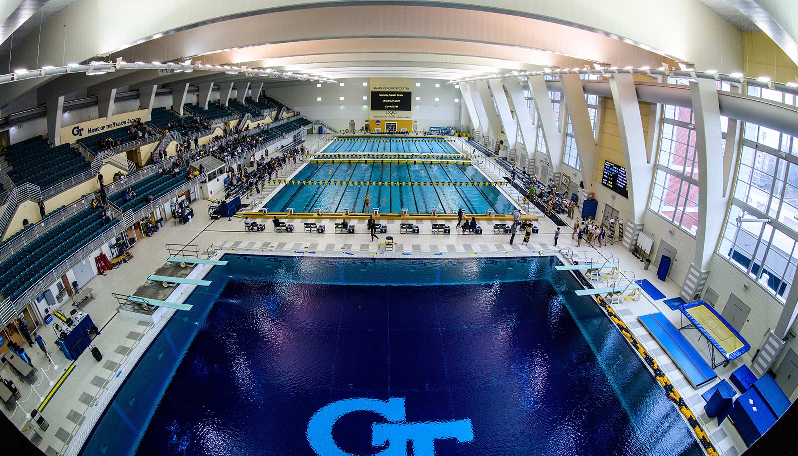 A high-up shot looking down at the swimming pool shows all of the lanes and another pool without lanes next to the racing pool