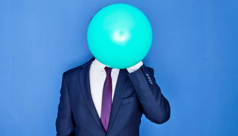 balloon obscures face of person in sharp suit