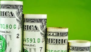 Dollar bills make up a bar chart that shows decline against a green background