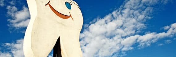 A giant tooth with a smiling face advertises a dentist