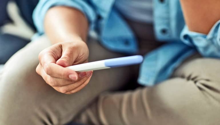 person holds pregnancy test