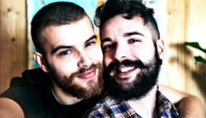 A couple pose for a selfie while hugging