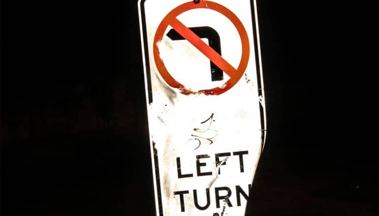 A sign reads "No left turn" and has a red line through a left turn symbol