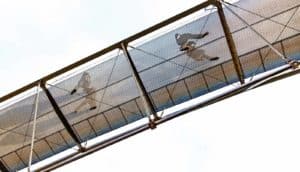 Pedestrians walk across a bridge made of metal