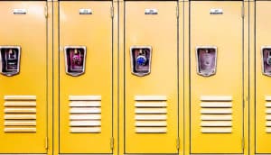 A row of yellow school lockers with padlocks on them