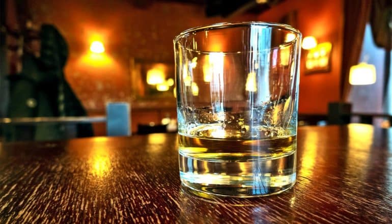 A glass of whiskey on a bar counter