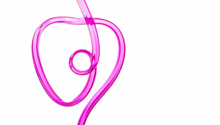 A pink, twisty drinking straw in the shape of a heart