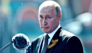 Vladimir Putin speaks in front of a microphone while outside