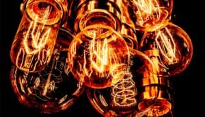 A group of lightbulbs glowing orange against a black background.