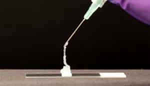 goop goes from syringe to coil on microscope slide