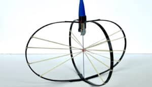 The jumping device has two crossed ovals of black material with several bands running across their center and a blue conical top.