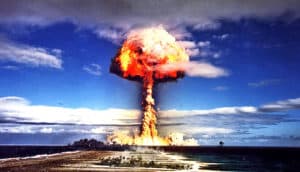 The mushroom cloud from a nuclear bomb test explosion over an island