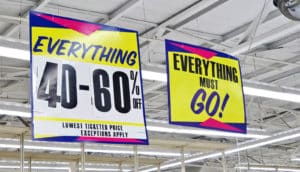 signs hanging from ceiling say "everything 40-60% off" and "everything must go!"