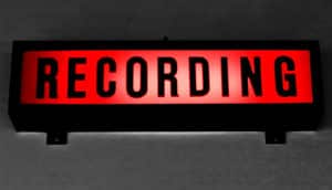 A light-up red sign reads "Recording" in black text.