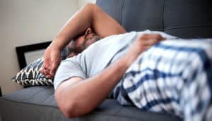 mature adult looks exhausted on couch