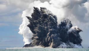 huge plume of ash mixes with clouds over ocean