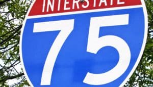 A shield-shaped highway road sign reads "Interstate 75" in white lettering.