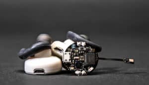 The Clearbuds have black rubber ear pieces on a white plastic frame with visible electronics on the outside.