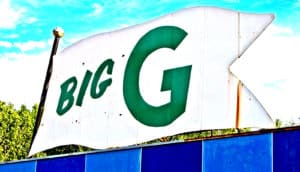 A metal sign in the shape of a flag reads "Big G" in green letters.