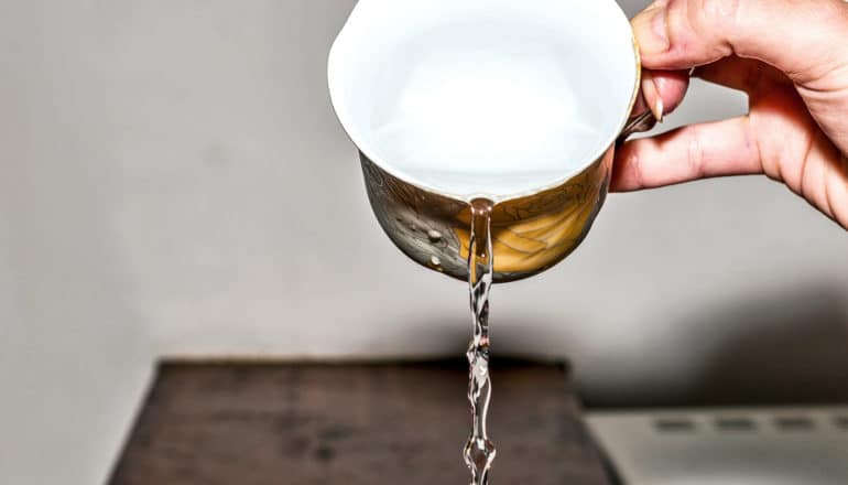 A person pours out a mug of water.