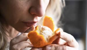 person sniffs clementine