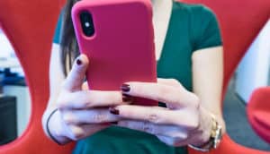 hands hold phone in pink case