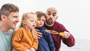 dads and young kids blow bubbles