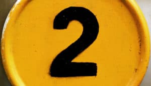 A number 2 is written in black on a yellow surface.