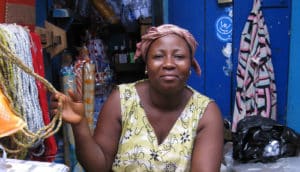 woman holds beads in market stall