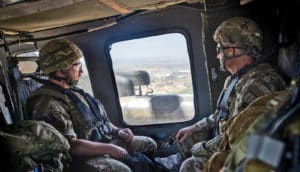 two soldiers look out plane window