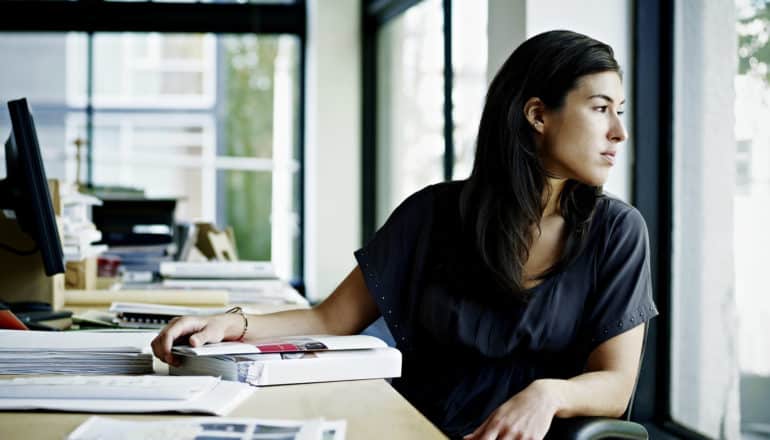 person at desk looks out window