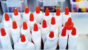 Many orange-topped glue bottles