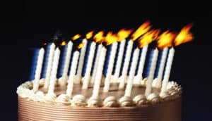 birthday cake with candles in process of being blown out