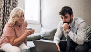 boomer and millennial consider laptop together