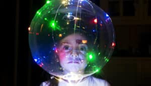 child's face behind clear globe with glowing lights