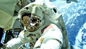 An astronaut in a full space suit above the Earth during a spacewalk.